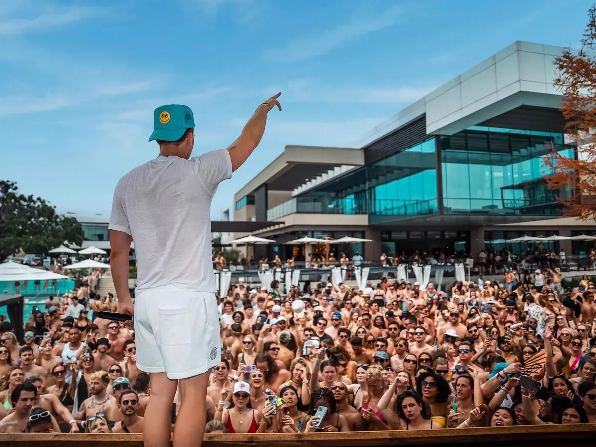 DJ performing to massive crowd at Village Beach Club